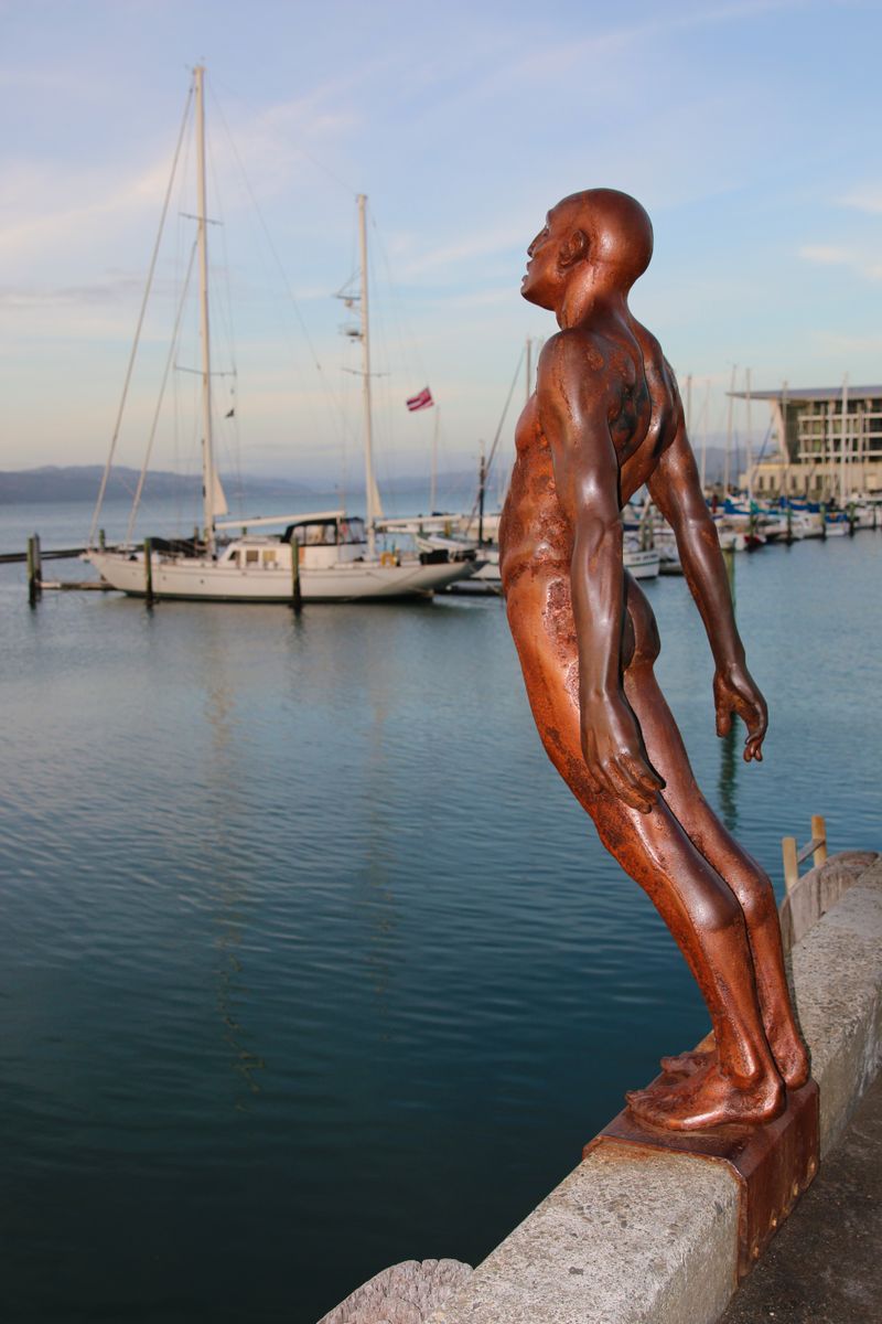 Solace in the Wind statue leaning over Wellington harbour