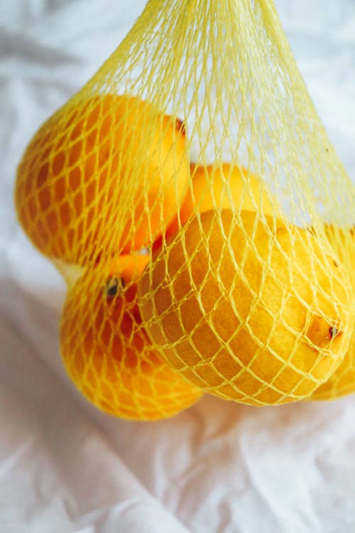 Free Bunch of Lemons In A Net In Close Up Photography Stock Photo