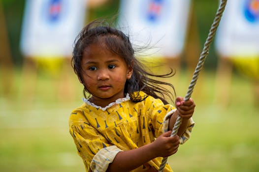 A young girl in a yellow dress joyfully swings outdoors, capturing the essence of childhood playfulness and freedom.