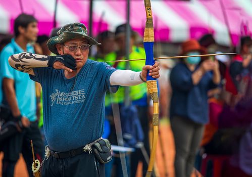 A focused archer preparing to shoot during an outdoor archery event in Taiwan.