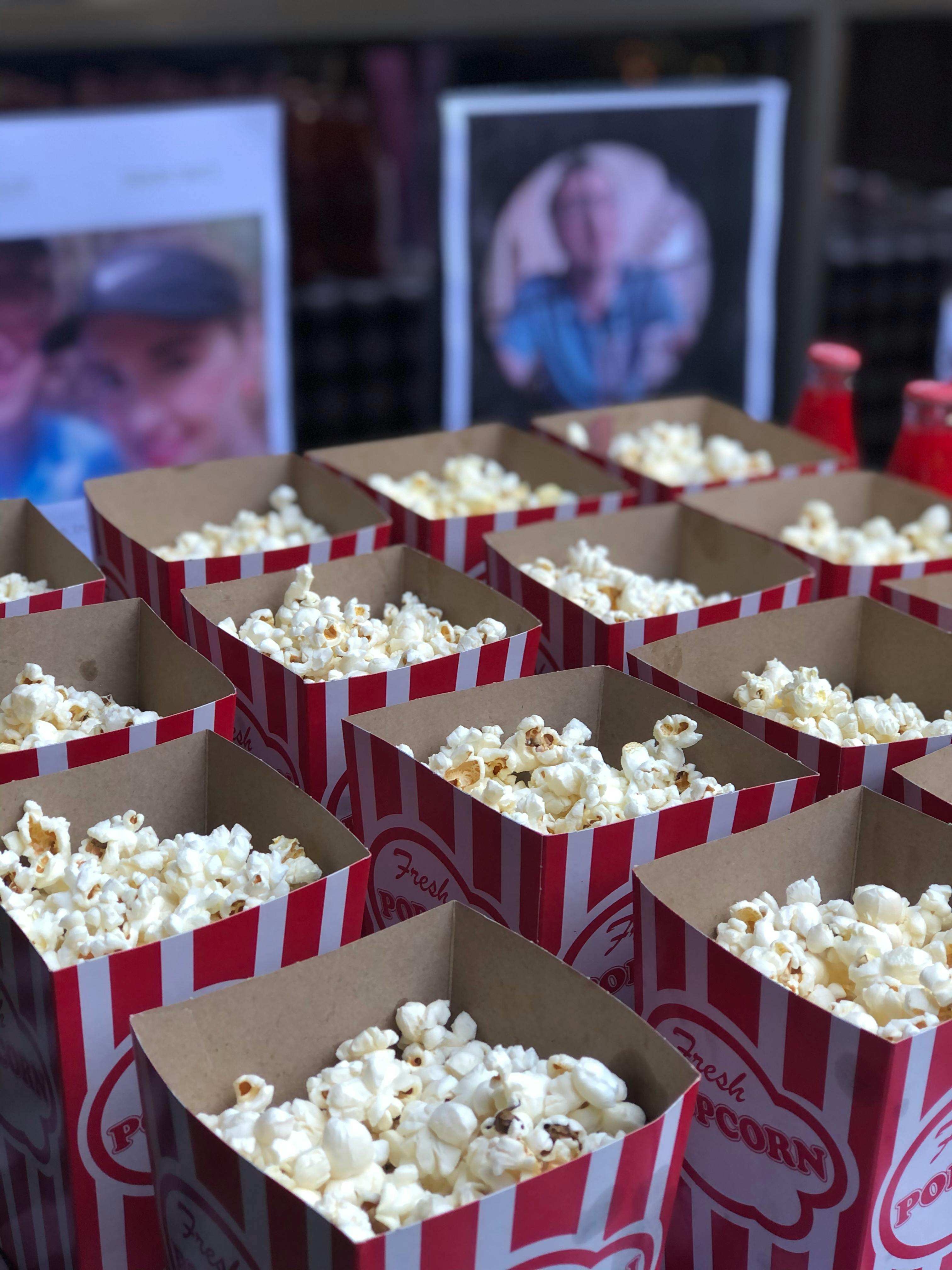 Free Rows of fresh popcorn in red and white striped boxes, perfect for events or movie nights. Stock Photo