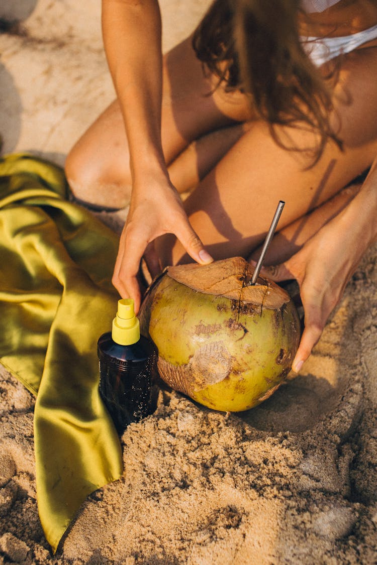 Person Holding Fresh Coconut With Straw