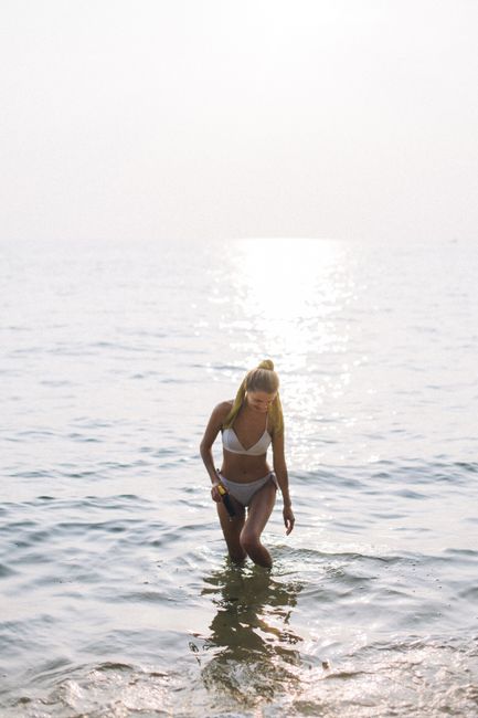 A woman in swimwear enjoying a sunlit day at the beach. Perfect summer vibes.
