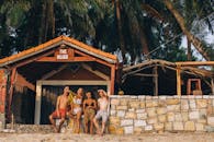 一群朋友在阳光明媚的日子里在海滩酒吧放松，捕捉无忧无虑的夏日氛围