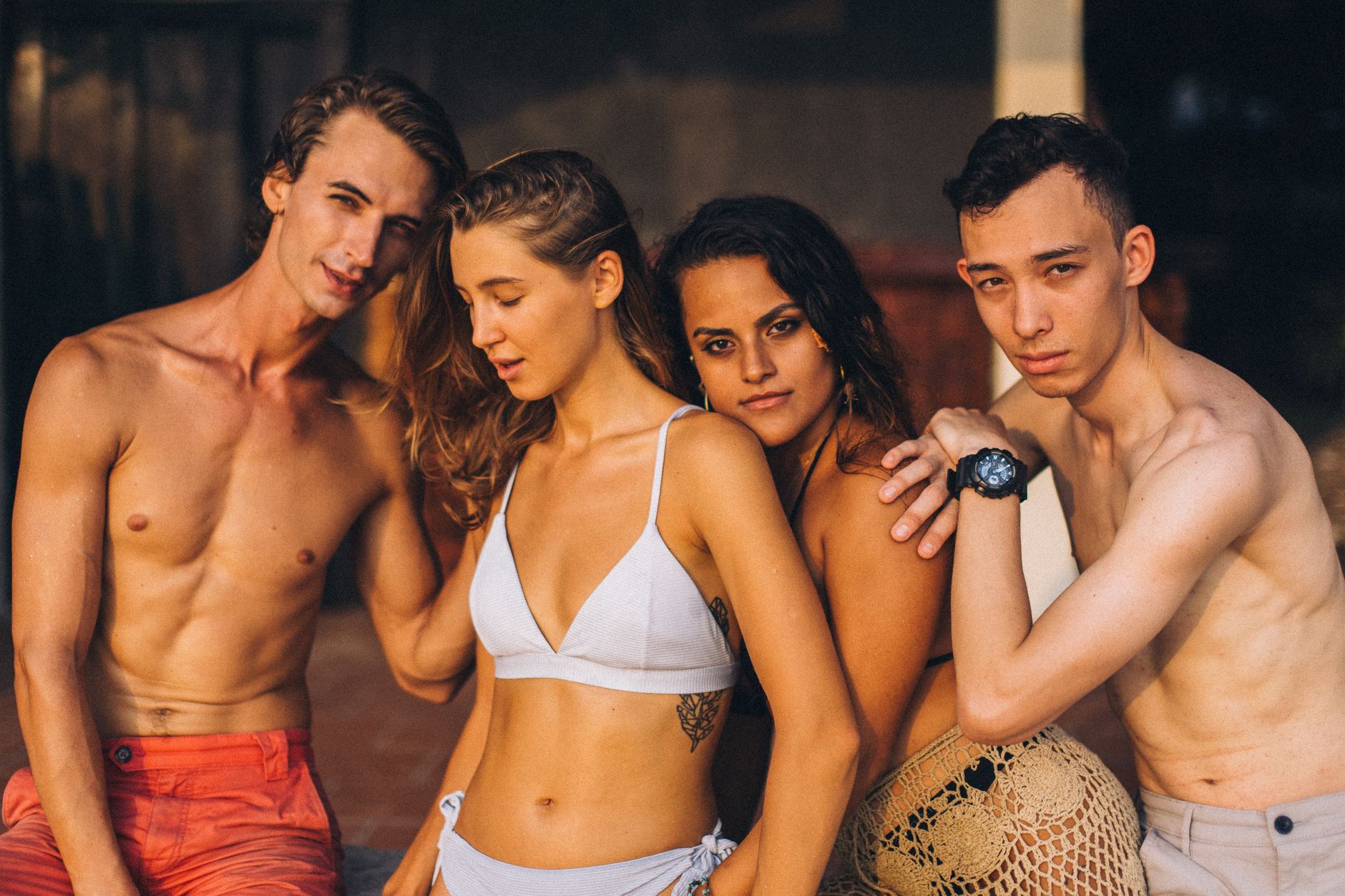 A group of stylish young adults posing in swimwear, enjoying sunshine.