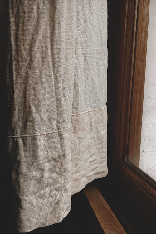 White Textile Near Brown Wooden Framed Glass Window 