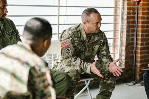 Free Military veterans engaging in a supportive group therapy session indoors. Stock Photo