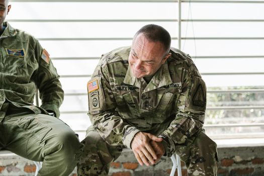 Military veterans in camouflage uniforms attending a supportive group therapy session.