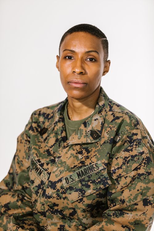 Free Portrait of a determined female U.S. Marine in camouflage uniform, conveying pride and professionalism. Stock Photo