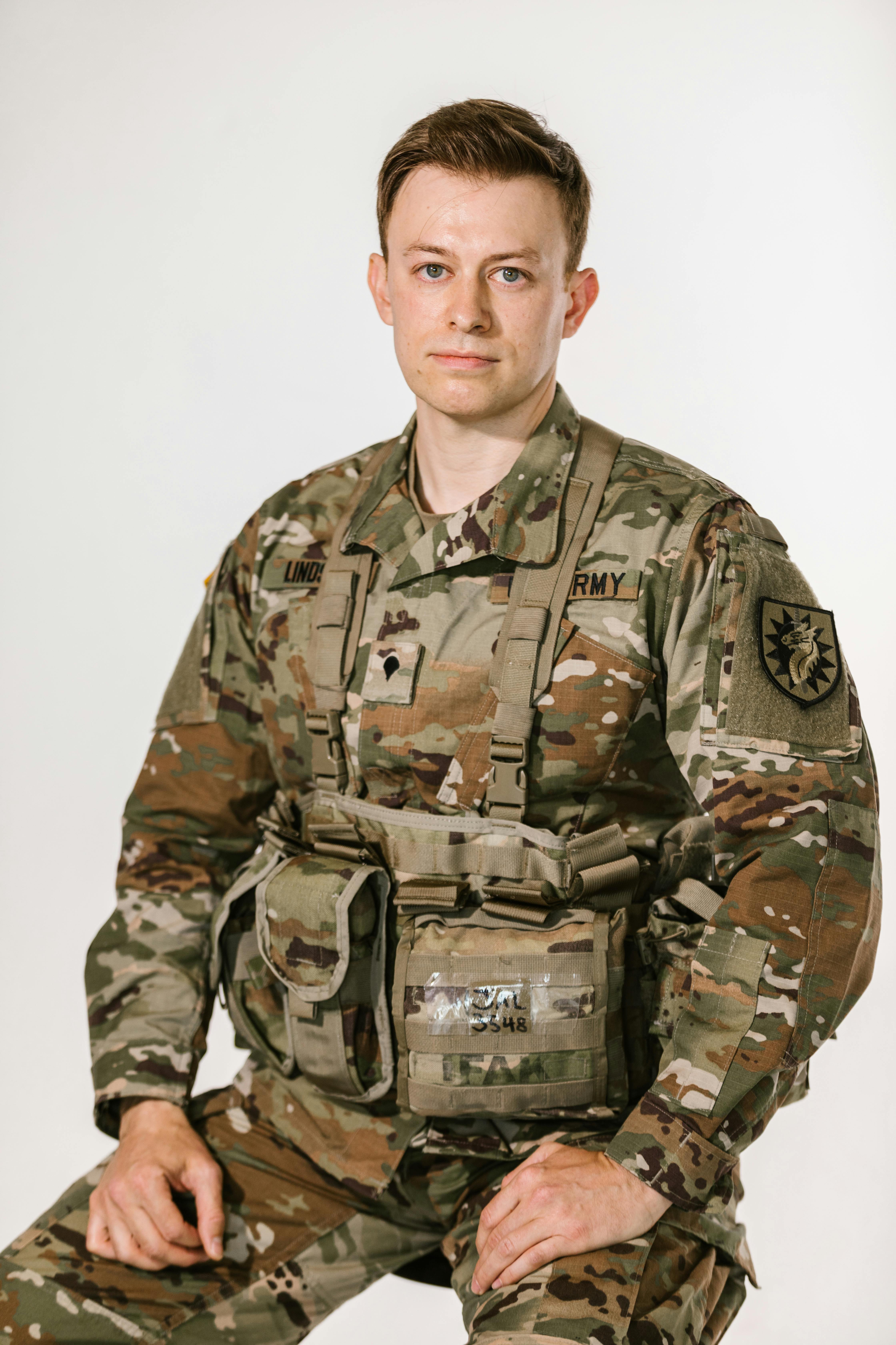 photo of soldier in green and brown camouflage army uniform