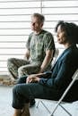 Photo of Man and Woman Sitting on Folding Chairs