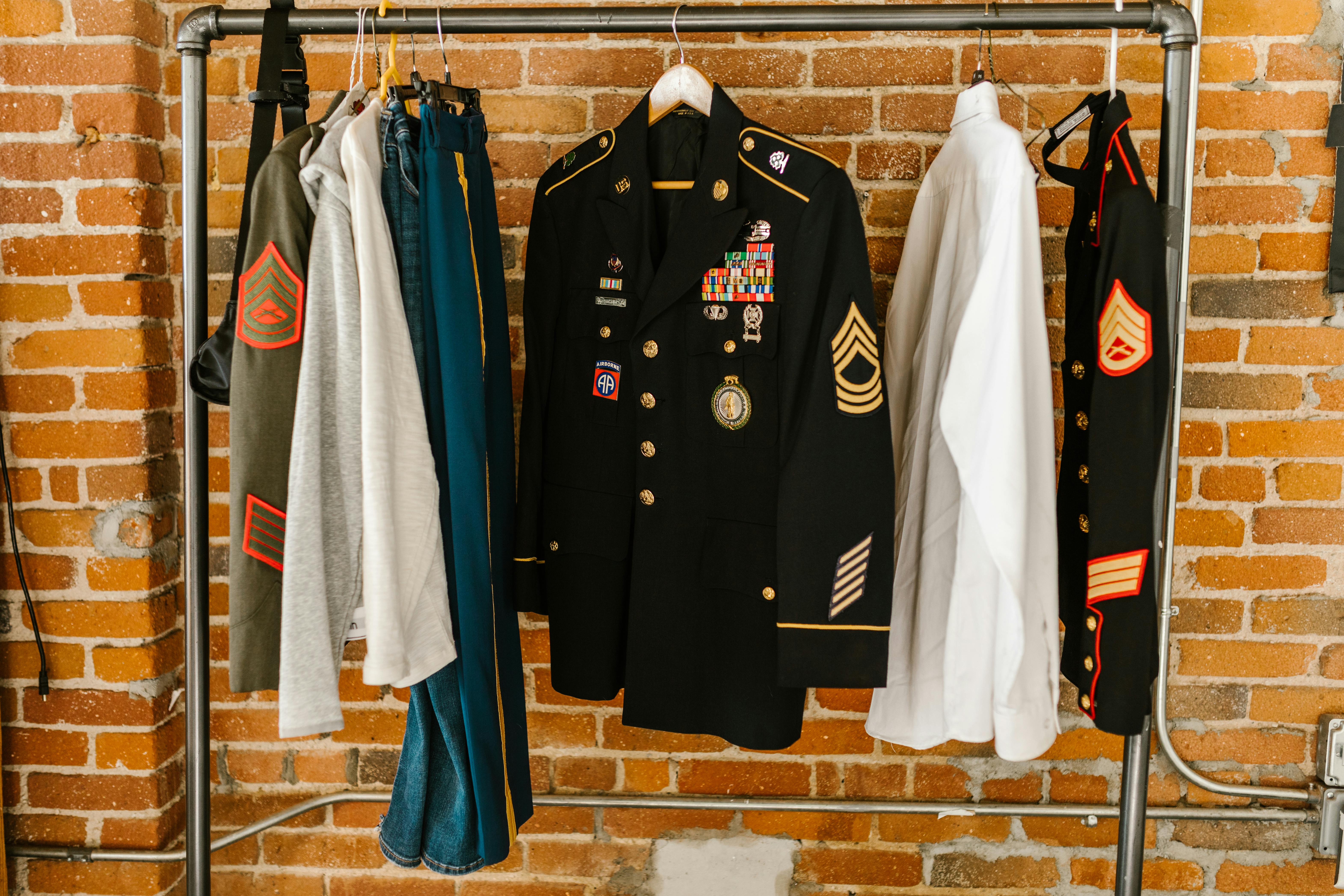 photo of military uniforms hanging on clothing rack