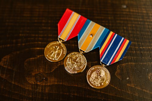 Close-Up Photo of Medals on Wooden Surface