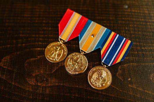 Close-Up Photo of Medals on Wooden Surface