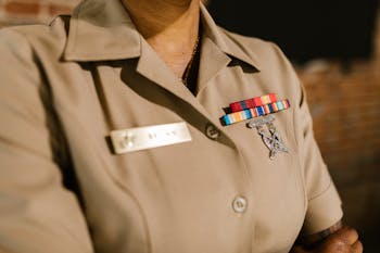 Close-Up Photo of Person Wearing Beige Military Uniform 