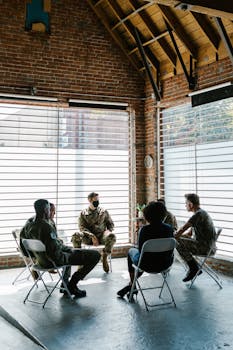 Soldiers in a group therapy session discussing mental health indoors.