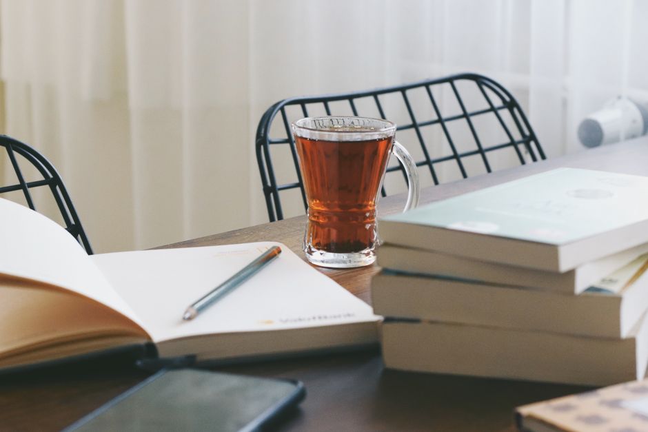 本、トルコのお茶、木製テーブルが特徴の穏やかな室内環境。勉強やリラックスに最適です。