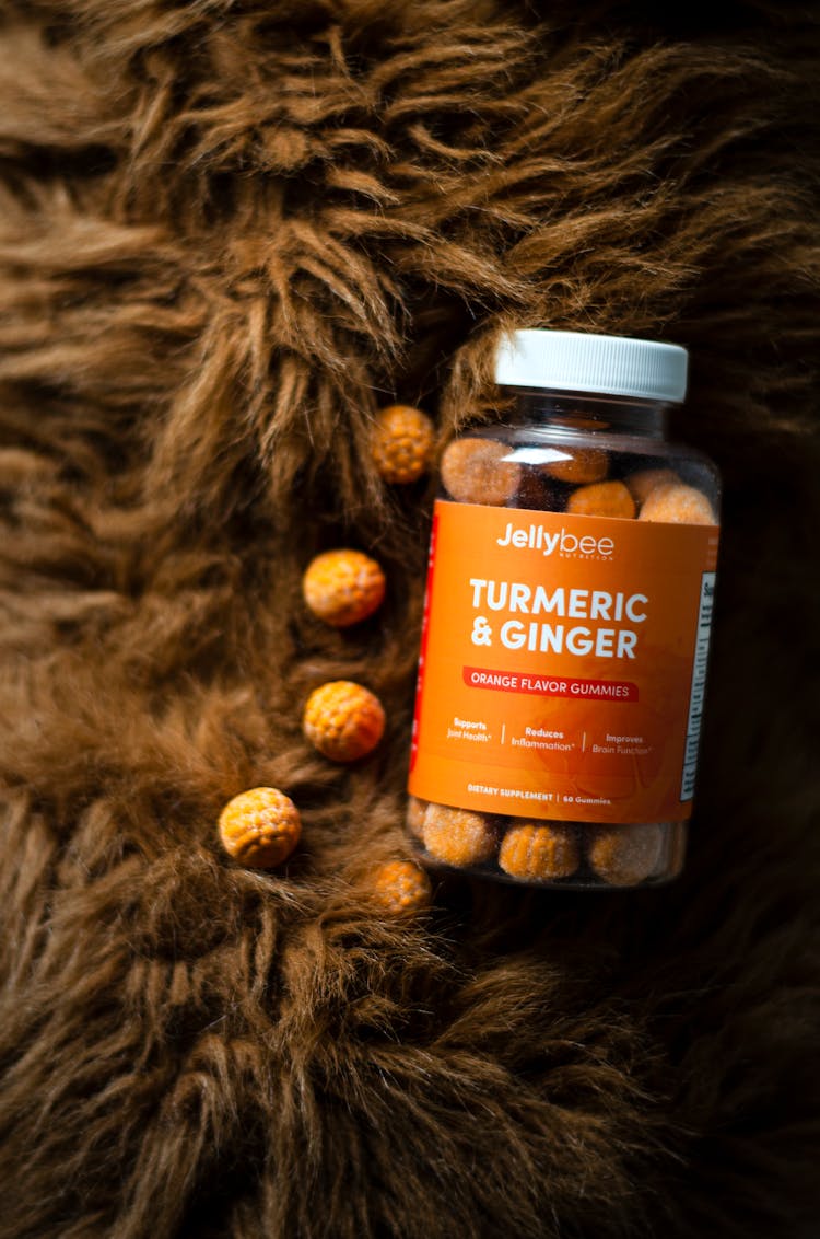 Bottle Of Turmeric And Ginger Orange Flavor Gummies On The Fur