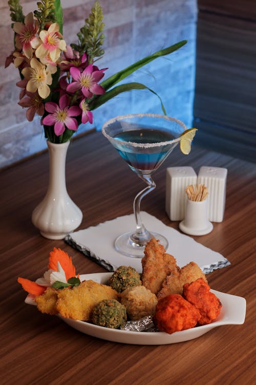 Fried Food on a Plate Beside a Cocktail Drink