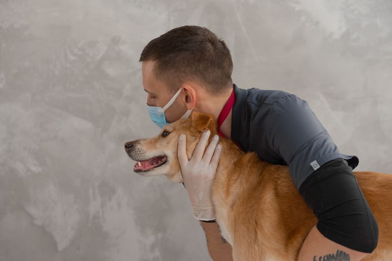 Caring veterinarian embracing a happy dog at ST Francis Veterinary Clinic