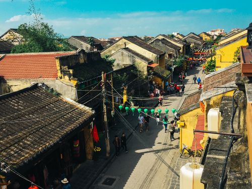 Free Colorful street view of a traditional town with vibrant lanterns, showcasing classic architecture and bustling street life. Stock Photo