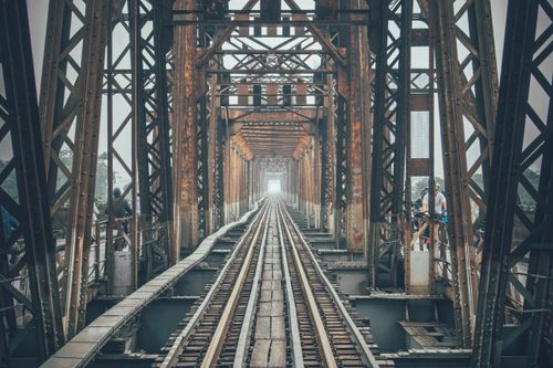 Free Vintage railway bridge with steel beams and train tracks in Hanoi, showcasing architectural symmetry. Stock Photo