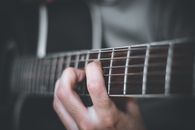 Person Playing Guitar in Grayscale Photography