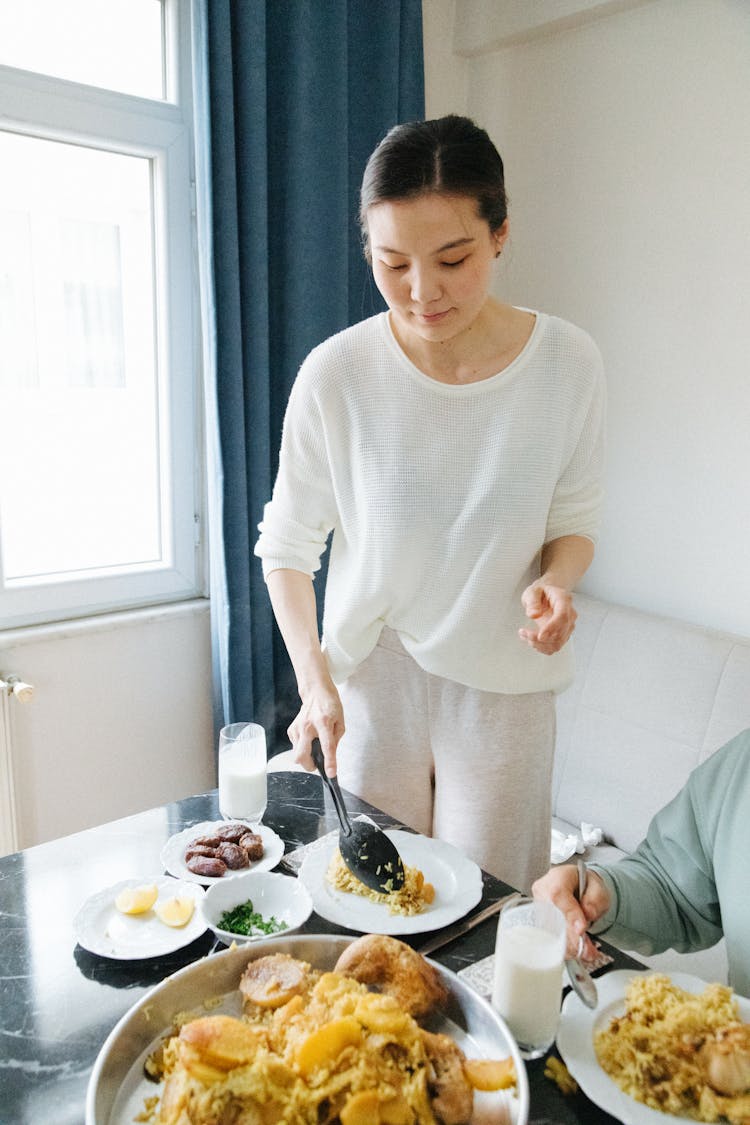 Woman Serving Meal At Home