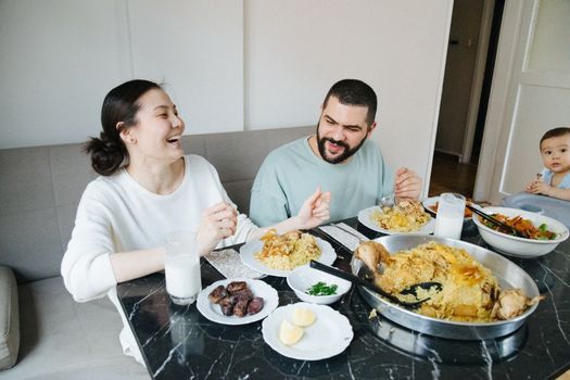 Happy family dining together with rice dishes and laughter, capturing a moment of joy and togetherness.