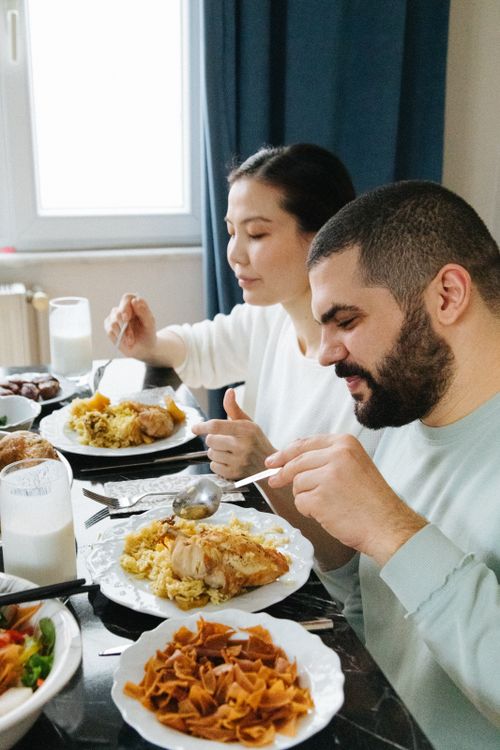 Free A couple enjoys a traditional meal at home, sharing a peaceful moment together. Stock Photo