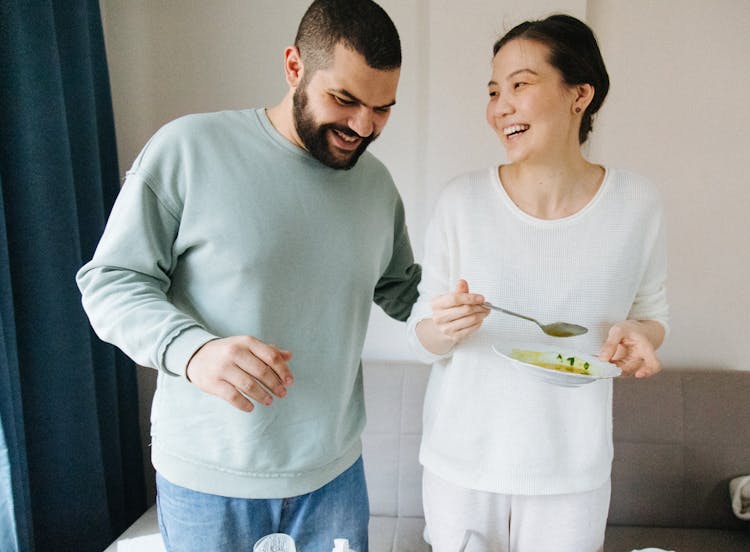 A Couple In Sweatshirts Laughing Together