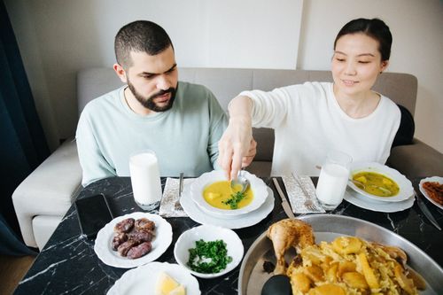 Free A couple sharing a traditional meal indoors, enjoying dishes like soup and maqluba in Istanbul. Stock Photo
