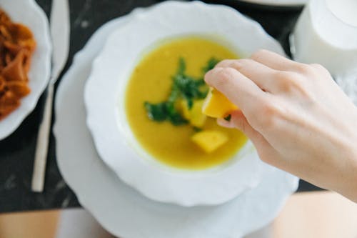 Free A Person Squeezing a Lemon on Lentil Soup Stock Photo