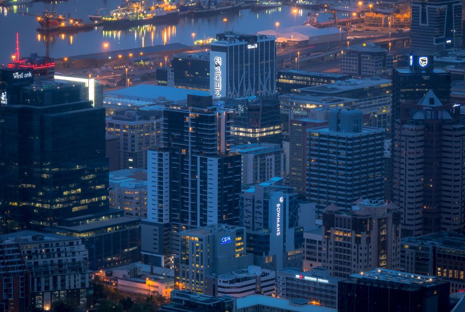 Stunning aerial view of Cape Town's illuminated cityscape at night, showcasing high-rise buildings and city lights.