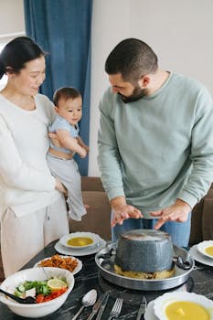 A young family gathers around a table sharing a meal with lively conversation.