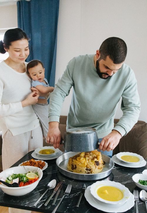 Free A family gathers around a table enjoying a homemade meal together. Stock Photo