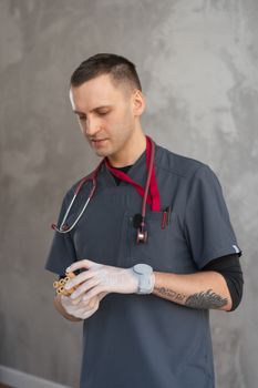 Young healthcare worker in uniform examining test tubes indoors.