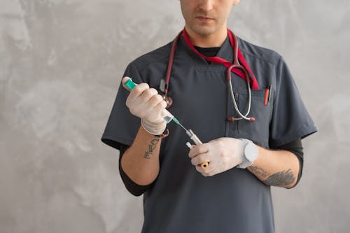 Man Holding a Test Tube and Syringe