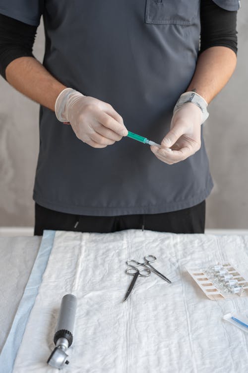 Close-Up Shot of a Person Holding a Syringe