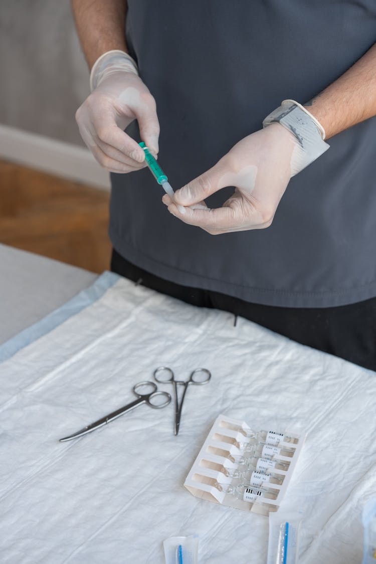 Man Wearing Gloves Holding A Syringe