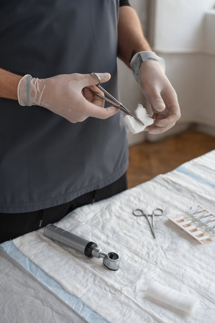 Close-Up Shot Of A Person Cutting Gauze Using Scissors