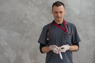 Man in Blue and Red Polo Shirt Holding White Textile