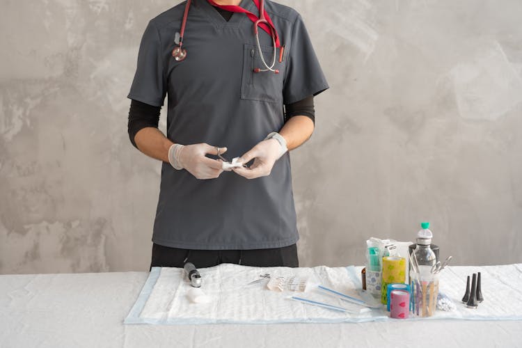 Close-Up Shot Of A Person Cutting Gauze Using Scissors