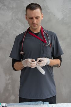Doctor wearing gloves and holding syringe in medical setup