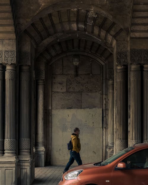 A Man in Yellow Jacket Walking on Tunnel