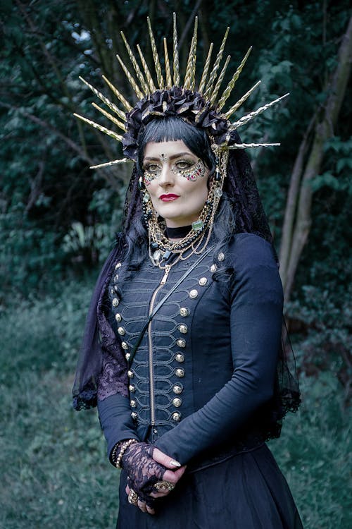 Woman in an Old-fashioned Black Dress with a Face Gems and a Spiked Headdress
