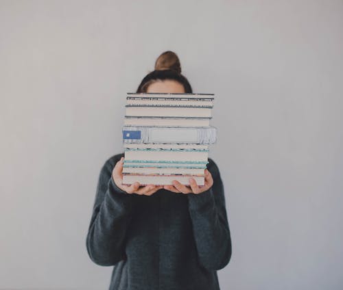 Free Anonymous woman with pile of books Stock Photo