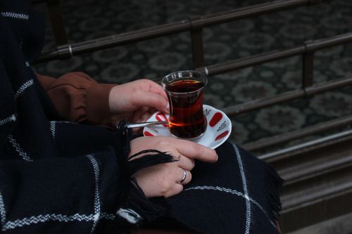 Free A close-up of hands holding a traditional glass of tea, exuding warmth and comfort. Stock Photo