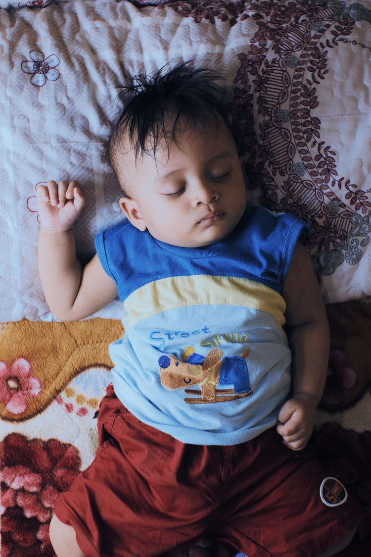 Little Boy Sleeping On Soft Bed