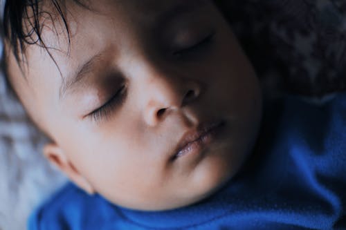 Tranquil ethnic boy sleeping on bed